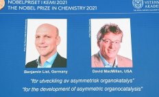 A screen displays the co-winners of the 2021 Nobel Prize in Chemistry, Germany's Benjamin List (left) and David MacMillan of the United States, during a press conference at the Royal Swedish Academy of Sciences in Stockholm, Sweden, on October 6, 2021. Germany's Benjamin List and David MacMillan of the United States on October 6, 2021 won the Nobel Prize in Chemistry for their development of a precise new tool for molecular construction, the jury said. The duo was awarded 