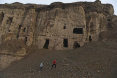 Athletes run uphill as they warm up before they train in Muay Thai form of martial arts atop the hills of Salsal Buddha, the site of the Buddhas of Bamiyan statues, which were destroyed by the Taliban in 2001, in Bamiyan province on March 14, 2021. 
