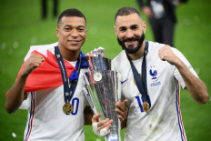 France's forward Kylian Mbappe (left) and France's forward Karim Benzema (right) celebrate with the trophy at the end of the Nations League final football match between Spain and France at San Siro stadium in Milan, on October 10, 2021. 
