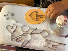 In this picture taken in Seoul on October 10, 2021, street vendor Lim Chang-joo stamps an umbrella shape onto a dalgona, a crisp sugar candy featured in the Netflix smash hit series Squid Game, for which he and his wife Jung Jung-soon were hired to be on set to make during production. Simple, sweet, and fictionally fatal: the stallholder who makes the traditional South Korean children's treat featured in global cultural phenomenon Squid Game -- and once associated with post-war poverty -- has hit a real-life jackpot.
