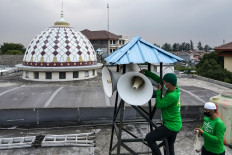 This picture taken on Sept. 7, 2021 shows officials inspecting a mosque's speakers in Jakarta.
