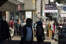 In this file picture taken on July 3, 2021, people walk through the city streets of Mbabane as a tense calm returns to Eswatini after days of violent widespread pro-democracy protests.