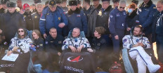 This handout video grab taken and released on October 17, 2021 by the Russian Space Agency Roscosmos shows crew members Roscosmos cosmonaut Oleg Novitskiy (center), Russian actress Yulia Peresild (left) and film director Klim Shipenko resting in chairs after landing, southeast of the Kazakh town of Zhezkazgan, on October 17, 2021. The Russian actress and the film director returned to Earth after spending 12 days on the International Space Station (ISS) shooting scenes for the first movie in orbit.