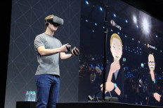 Facebook co-founder and chief executive, Mark Zuckerberg, speaks at an Oculus developers conference while wearing a virtual reality headset in San Jose, California on October 6, 2016. Facebook unveiled new hardware for its Oculus division as part of a stepped-up effort to integrate virtual reality with the leading social network. The new offerings aim to get an array of virtual reality gear to consumers in the coming months, including a new 