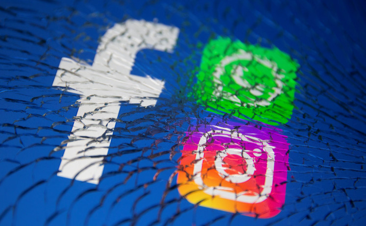 Facebook, Whatsapp and Instagram logos are displayed through broken glass in this illustration taken October 4, 2021. 