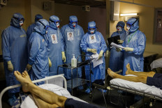 Medics wearing personal protective equipment (PPE) work in the intensive care unit for Covid-19 coronavirus patients in the Moscow Sklifosovsky emergency hospital in Moscow on October 20, 2021. Russia said on October 20, 1,028 people died of Covid over the past 24 hours, a new record, as President Vladimir Putin mulls introducing nationwide restrictions to curb the spread of the disease.