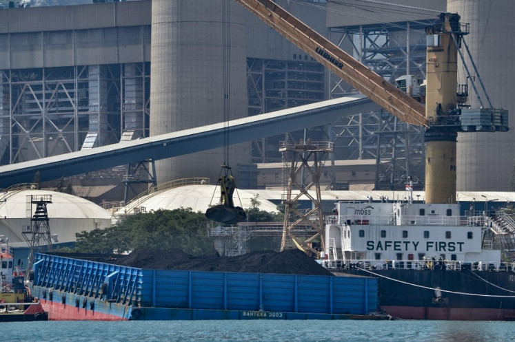 Coal is unloaded from a barge on Sept. 22, 2021 at the Suralaya coal-fired power plant in Cilegon, Banten.