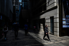 Pedestrians walk in the Central district of Hong Kong on April 29, 2021.