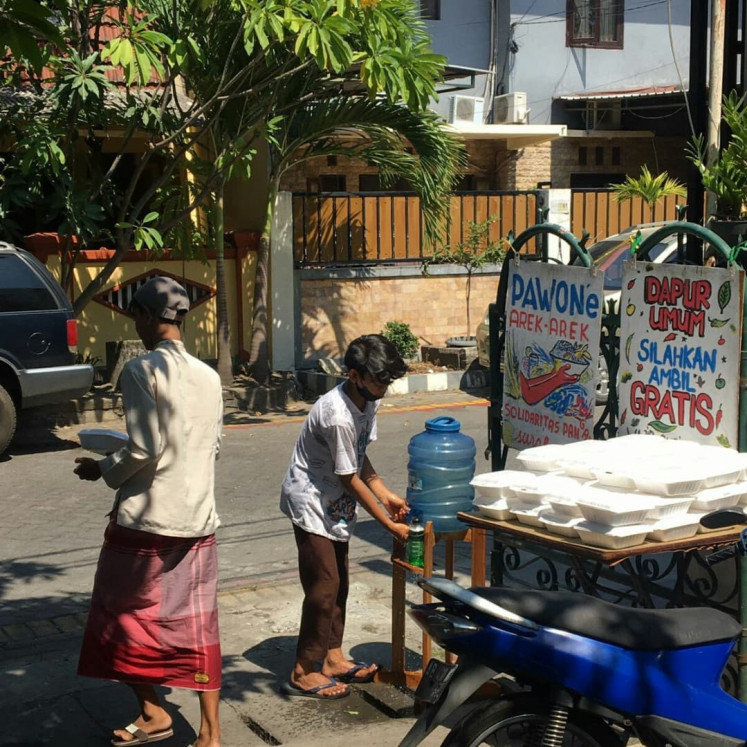 For everyone: Locals wash their hands and take food from Pawone Arek-Arek's kitchen in Surabaya. (Courtesy of Pawone Arek-Arek)