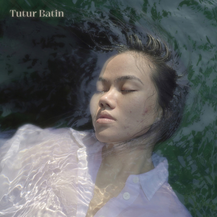 Imperfection: The cover of Yura Yunita's new album Tutur Batin. The 30-year-old singer-songwriter is seen without make-up and floating on water. (Courtesy of Merakit) 