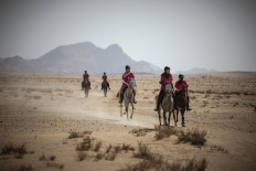 Former miss France Camille Cerf (C) rides her horse during the fourth stage of the Gallops of Jordan at the Wadi Rum desert, 300 kilometers south Ammam, on October 28, 2021.