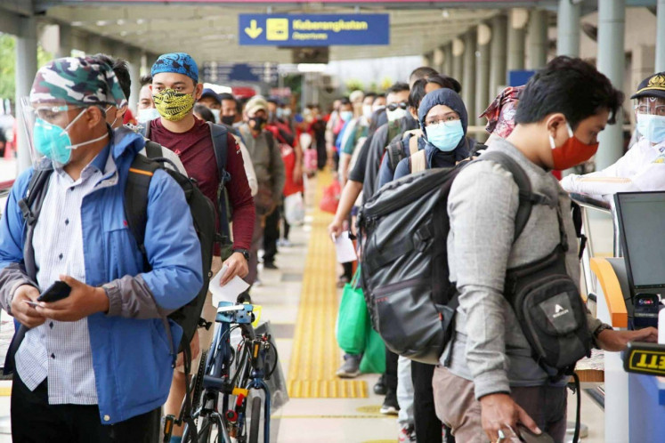 Passengers wait to board an intercity train at Senen Station in Central Jakarta in 2020, as they head to their hometowns in the eastern part of Java for the New Year holiday. State-owned railway operator PT Kereta Api Indonesia at that time required passengers and staff to adhere to strict health protocols to curb COVID-19.