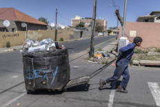 A reclaimer pulls a trolley full of waste after a graffiti artist has sprayed it as part of an initiative to make their graffiti art mobile and make reclaimers more visible and identifiable in Johannesburg on November 2, 2021.