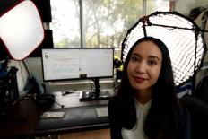 This picture taken on October 13, 2021 shows Australian 'finfluencer' Queenie Tan posing for pictures inside a studio at her apartment in Sydney.