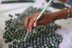 This photo taken on October 10, 2021 shows a woman working in a jade workshop in Myanmar's Sagaing region. Myanmar jade traders are running from junta troops and dodging rebel attacks to sell dwindling volumes of the green gemstone, as the billion-dollar industry loses its shine months on from the coup.
