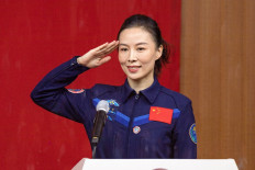 Chinese astronaut Wang Yaping, member of the second crew for China's new space station, salutes as attends a briefing the day before his launch, at the Jiuquan Satellite Launch Centre in the Gobi desert, in northwest China on October 14, 2021. 