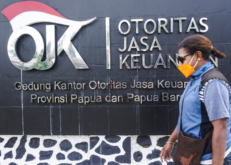 A woman walks on Oct. 27, 2021 past the signage of the the Financial Services Authority (OJK) Papua and West Papua office in Jayapura, the provincial capital of Papua. (Antara/Indrayadi TH)