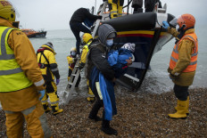 Migrants are helped ashore from a RNLI (Royal National Lifeboat Institution) lifeboat at a beach in Dungeness, on the south-east coast of England, on November 24, 2021, after being rescued while crossing the English Channel. The past three years have seen a significant rise in attempted Channel crossings by migrants, despite warnings of the dangers in the busy shipping lane between northern France and southern England, which is subject to strong currents and low temperatures.