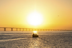 A boat makes its way toward the Hong Kong–Zhuhai–Macau bridge as an aircraft prepares to land at Hong Kong International Airport on Nov. 20, 2021.