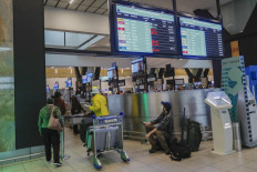 A passenger holds his mobile phone while looking at an electronic flight notice board displaying cancelled flights at OR Tambo International Airport in Johannesburg on November 27, 2021, after several countries banned flights from South Africa following the discovery of a new Covid-19 variant Omicron. A flurry of countries around the world have banned ban flights from southern Africa following the discovery of the variant, including the United States, Canada, Australia,Thailand, Brazil and several European countries. The main countries targeted by the shutdown include South Africa, Botswana, eSwatini (Swaziland), Lesotho, Namibia, Zambia, Mozambique, Malawi and Zimbabwe.