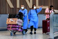 International travelers wearing personal protective equipment (PPE) arrive at Melbourne's Tullamarine Airport on Nov. 29 as Australia records its first cases of the Omicron variant of COVID19. 