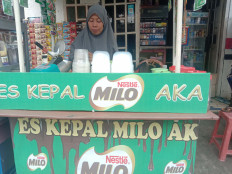 Forgotten one: Ela Nurlaila, 37, makes an es kepal milo for a customer at her stall in Keagungan, West Jakarta. (JP/Radhiyya Indra)