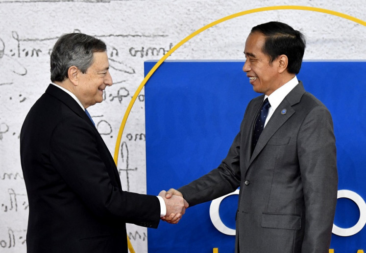 Old and new: Then Italian prime minister Mario Draghi (left) greets President Joko "Jokowi" Widodo as he arrives at the Group of 20 Summit in Rome on Oct. 30, 2021. 