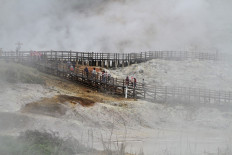Visitors tour Sikidang crater at Dieng Plateau in Banjarnegara, Central Java, on Nov. 27, 2021. In collaboration with private
company PT Geo Dipa Energi, the local administration is developing the area into an educational geothermal tourist destination.