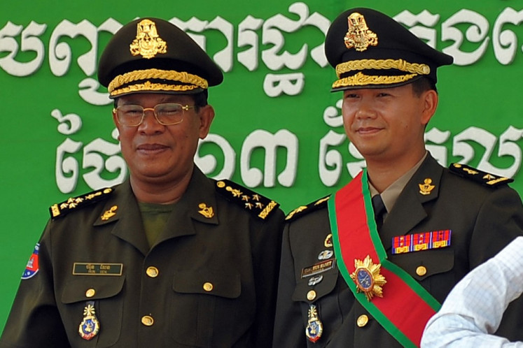 In this file photo taken on October 13, 2009, Cambodia's Prime Minister Hun Sen (left) poses with his son Hun Manet during a ceremony at a military base in Phnom Penh. Cambodia's strongman Prime Minister Hun Sen, who has led the country for more than three decades, on December 2, 2021 backed his eldest son Hun Manet to take over the top job, paving the way for a political dynasty.
