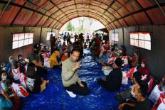 This handout photo taken and released by the Indonesian Presidential Palace on December 7, 2021 shows President Joko 'Jokowi' Widodo (center) talking to people at a makeshift evacuation centre in Sumber Wuluh village in Lumajang, following the Mount Semeru eruption that killed at least 34 people. 