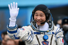Japanese billionaire Yusaku Maezawa waves before boarding the Soyuz MS-20 spacecraft prior to the launch at the Baikonur cosmodrome on December 8, 2021.