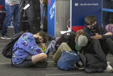 Travelers wait in line at Delta Airlines check-in at Los Angeles International Airport in Los Angeles, California, on December 24, 2021. Over 2,000 flights have been canceled and thousands delayed around the world as the highly infectious Omicron variant disrupts holiday travel. 