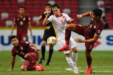 Vietnam's Nguyen Van Toan (center) fights for the ball with Thailand's Yusef Elias Dolah (right) during the second leg of the AFF Suzuki Cup 2020 football semi-final match between Vietnam and Thailand at the National Stadium in Singapore on December 26, 2021. 