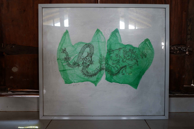 Green dragon: A painting titled Bhutakala Plastic No.4 has a dragon image painted on flattened used plastic bag. (JP/Alez Kurniawan Ulung)