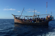 A wooden boat transports Rohingya refugees in the waters off Bireuen, Aceh, on Dec. 27, 2021.
