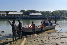 This handout photo taken and received from the Indonesian police on December 28, 2021 shows officers preparing to send supplies to Rohingya refugees aboard a wooden vessel off the coast of Indonesia's Aceh province, in Bireuen. 