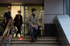 Pro-democracy activist and singer Denise Ho (C), a former board member of Stand News, leaves the Western Police Station after being released from custody in Hong Kong on December 30, 2021, following her arrest the previous day along with six other current and former staff members of the local media outlet under a British colonial-era law for 'conspiracy to publish seditious publication'.