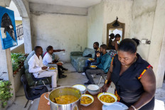 Relatives gather to eat a traditional soup on January 01, 2022 in Port-au-Prince, Haiti.