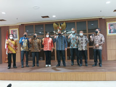 The Financial Services Authority (OJK) selection committee headed by Finance Minister Sri Mulyani Indrawati (center, wearing red batik) poses for a photo at the Finance Ministry on Dec. 31, 2021.