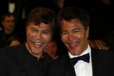 In this file photo taken on May 24, 2013, French scientific journalists Grichka and Igor Bogdanoff pose during the 66th edition Cannes Film Festival in Cannes.