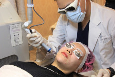 This photo taken on November 11, 2021 shows Kayla Zhang, a finance worker, receiving laser facial treatment at a beauty clinic in Shanghai.