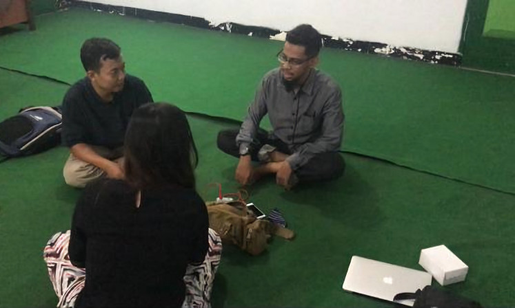 Social reintegration: Arif Budi Setyawan (left) talks to one of his mentees, Wildan (right), at a community engagement event in Singosari, Malang, in December 2019, as a part of a social reintegration program for former prisoners. (Courtesy of Kreasi Prasasti Perdamaian/Outreach Project)
