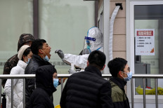 A man receives a nucleic acid test to check for the Covid-19 coronavirus at a testing centre along a street in Beijing on January 21, 2022.