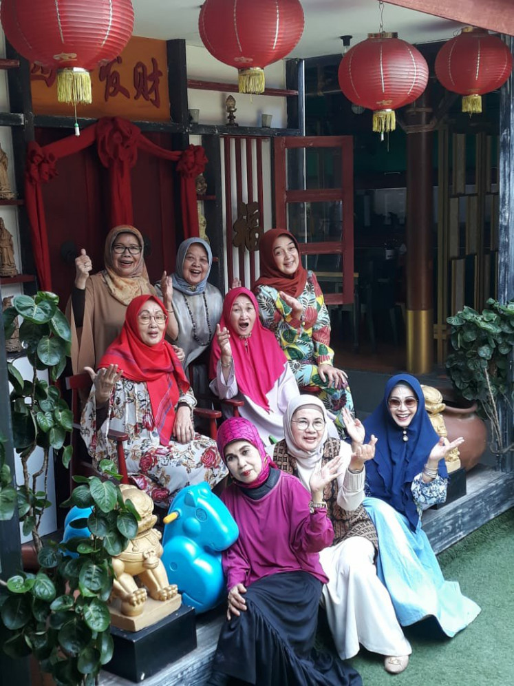 Decades-old friendship: Tien (center, below) and her arisan friends pictured in front of a restaurant where they held their monthly gathering in 2018. (Courtesy of Tien)