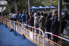 Residents wait in line to test for the COVID-19 coronavirus outside a building placed under lockdown at the Kwai Chung Estate public housing complex in Hong Kong on January 22, 2022, amid a rise in coronavirus cases fuelled by the Omicron variant. 