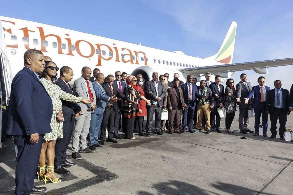 Ethiopian Airlines employees pose for a group photo in front of a Boing 737 MAX on the tarmac of the Bole International Airport in Addis Ababa on February1, 2022. Ethiopian Airlines is set Tuesday to operate the Boeing 737 MAX for the first time since a crash nearly three years ago killed all 157 people on board and triggered the global grounding of the aircraft.