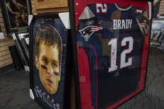 Tom Brady posters decorate the sports memorabilia shop Sportsworld in Saugus, Massachusetts on February 1, 2022. The store claims that items autographed by Brady are going up in price now that he has retired and that fans are always looking for original “Brady” items. The store once sold a plane ticket Tom Brady used. NFL icon Tom Brady confirmed his retirement from the sport on February 1, 2022, officially bringing the curtain down on a glittering 22-season career. 