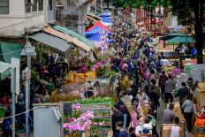 Hundreds of people crowd a lane as they shop at the Mongkok Flower Market ahead of the Lunar New Year in Hong Kong, China, on Jan. 29, 2022.