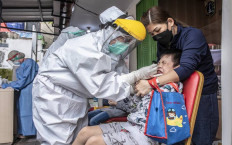 A health worker performs a swab antigen test on a child in Krukut subdistrict, West Jakarta, on Jan. 10. 