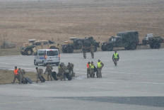 US troops walk from a US Air Force transport plane transporting military equipment and troops after landing at the Rzeszow-Jasionka airport in southeastern Poland, on February 6, 2022. A large contingent of US troops landed in Poland on February 6, 2022 as part of a reinforcement due to tensions with Russia, with their commander saying they aimed to deter 